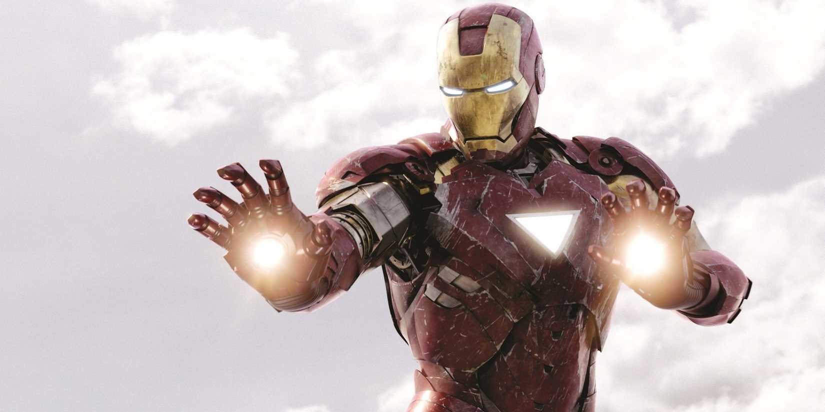 Homem de Ferro MCU pairando contra um céu nublado, preparando-se para disparar rajadas de laser com as palmas das mãos