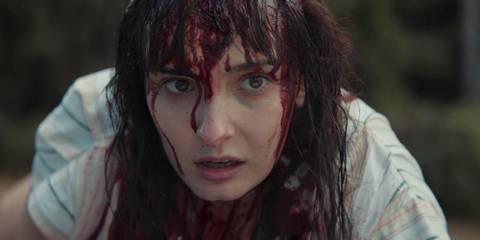 Mirabai Pease wears a shocked expression with her face all bloody in a scene from Evil Dead Rise