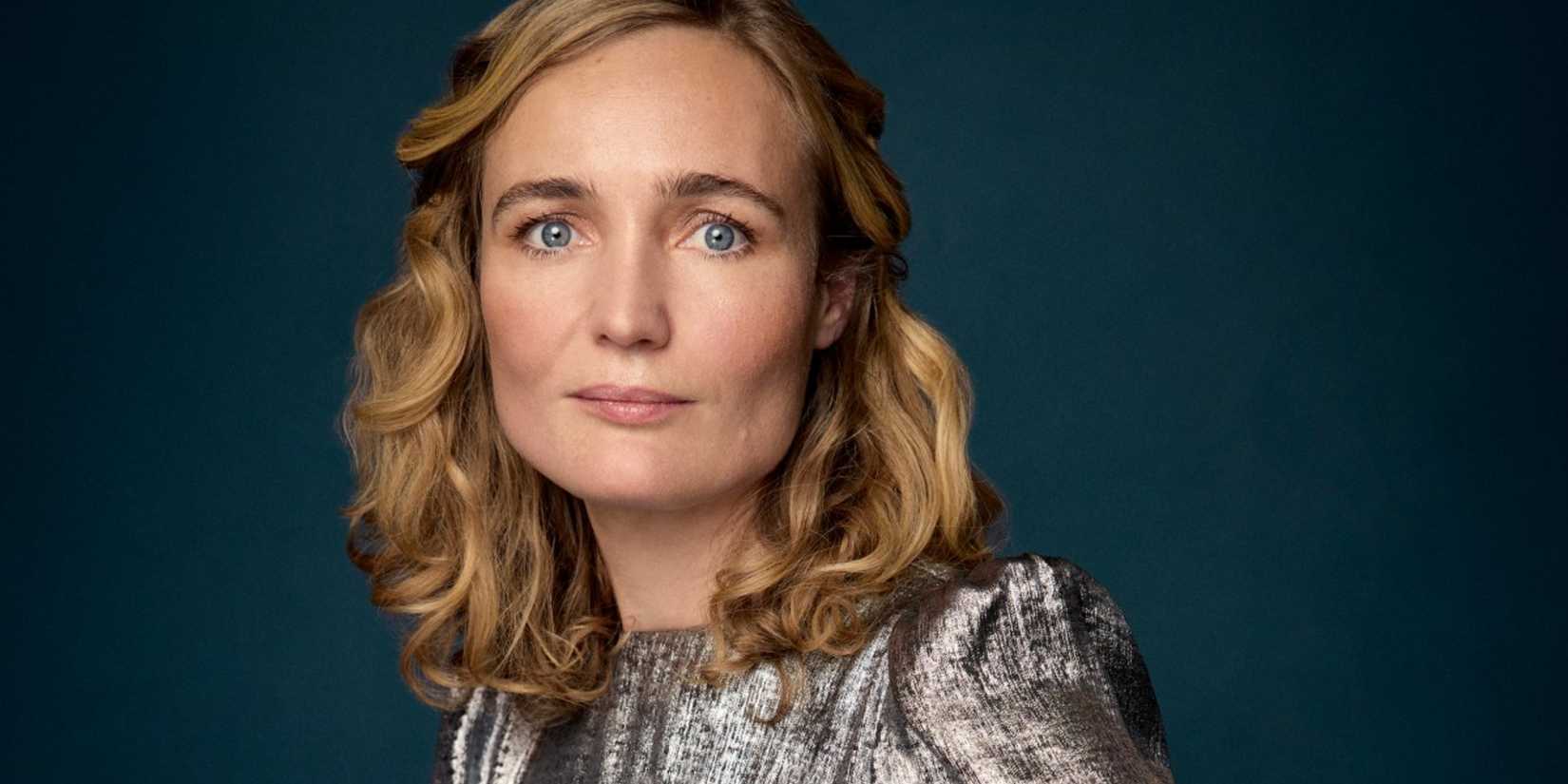 Molly Guinness smiling on a blue background