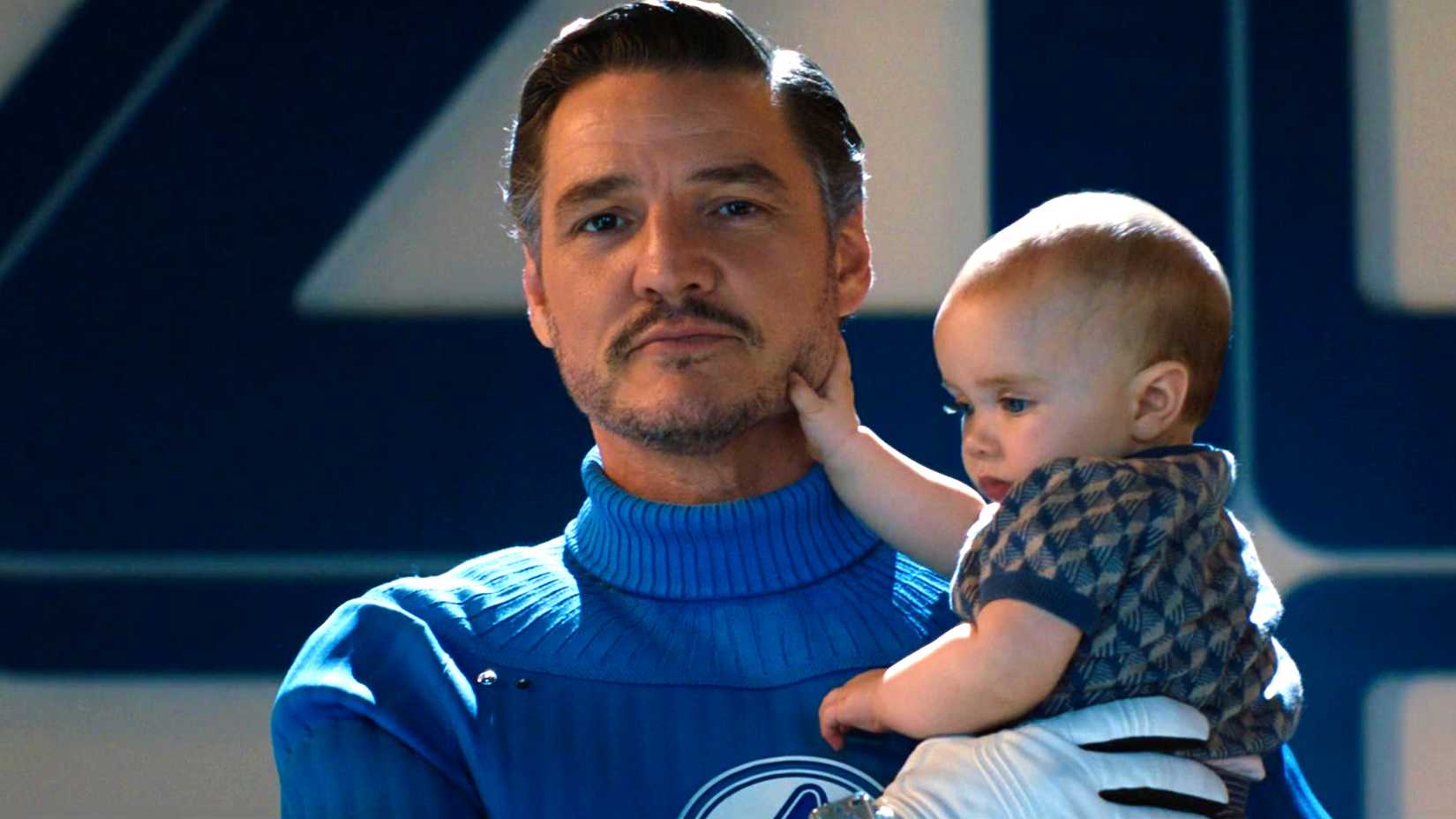 Reed Richards (Pedro Pascal) sorrindo enquanto segura Franklin Richards em O Quarteto Fantástico: Primeiros Passos