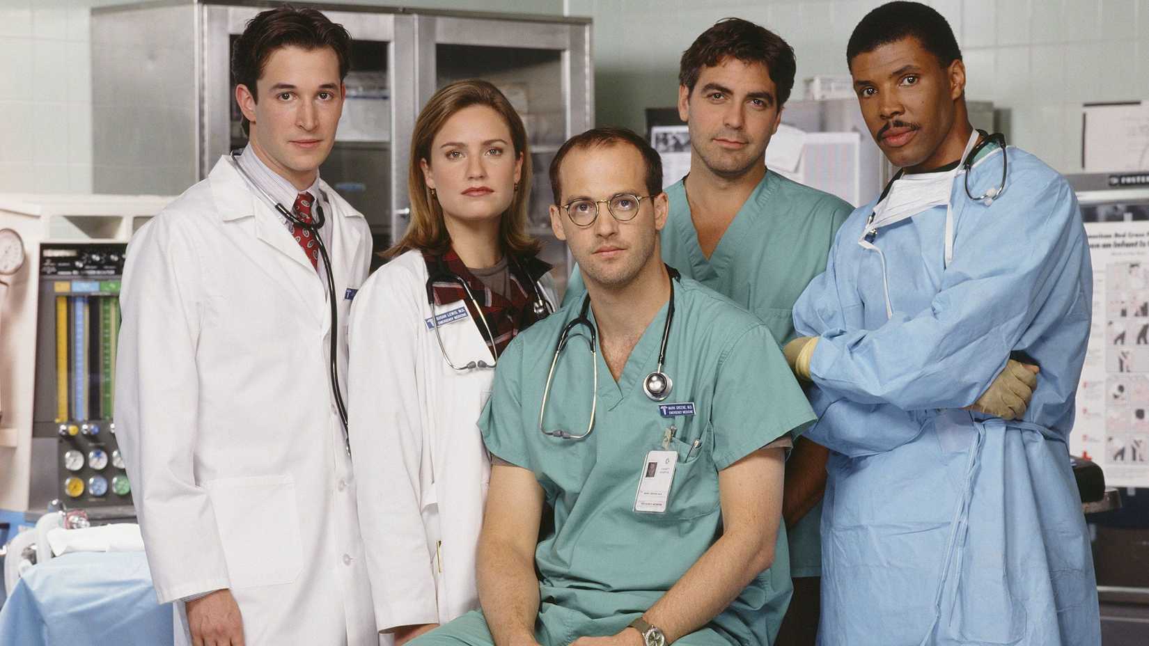 Publicity shot of John Carter, Susan Lewis, Mark Greene, Doug Ross, and Peter Benton staring at the camera in an ER room in ER