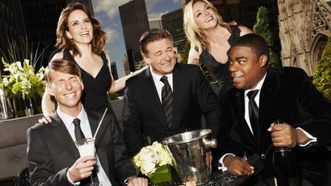 Publicity shot of Liz Lemon, Jack Donaghy, Tracy Jordan, Kenneth Parcell, and Jenna Maroney smiling at the camera in 30 Rock