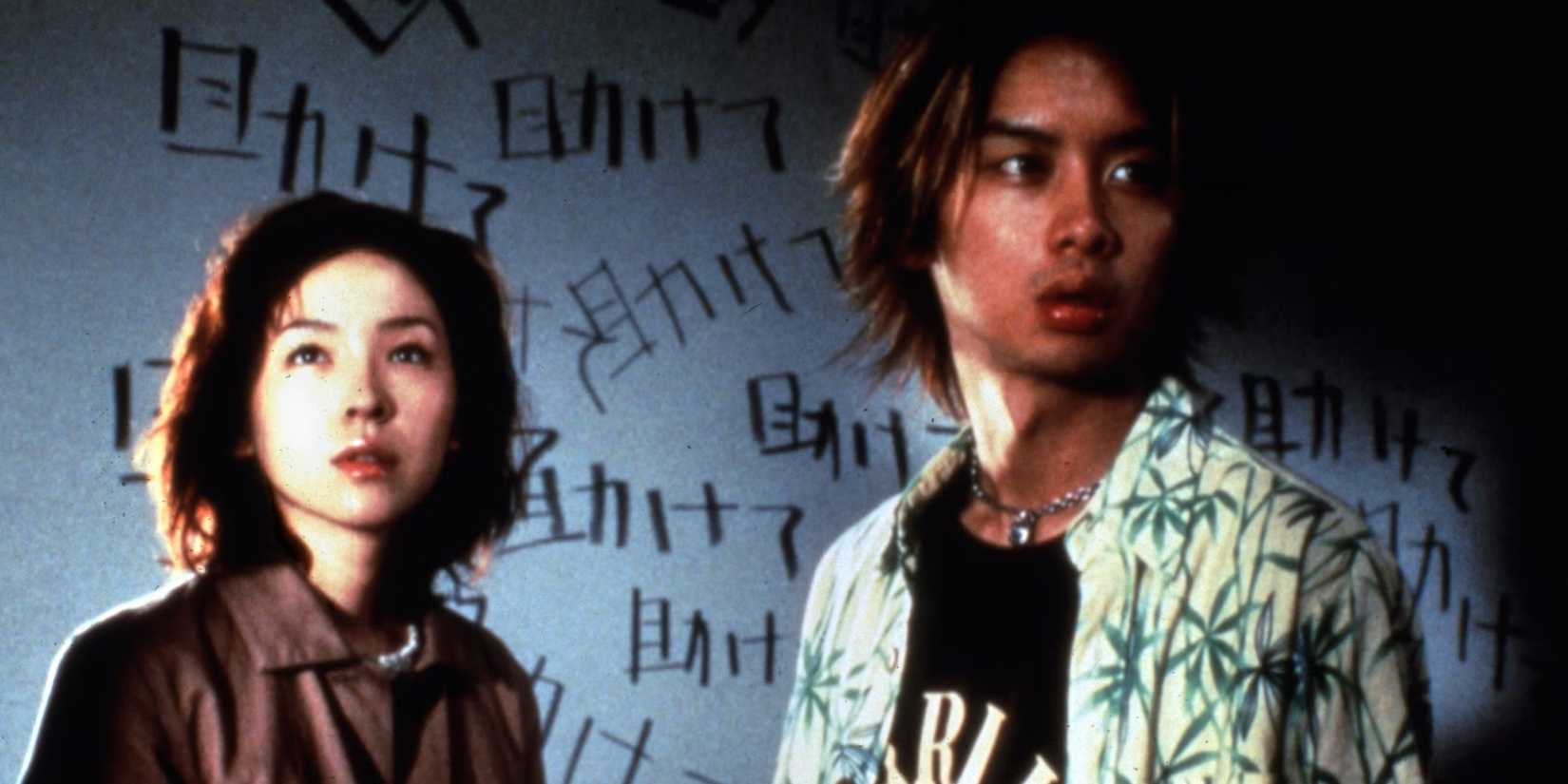 Two people standing in front of a wall with words written on it in Pulse
