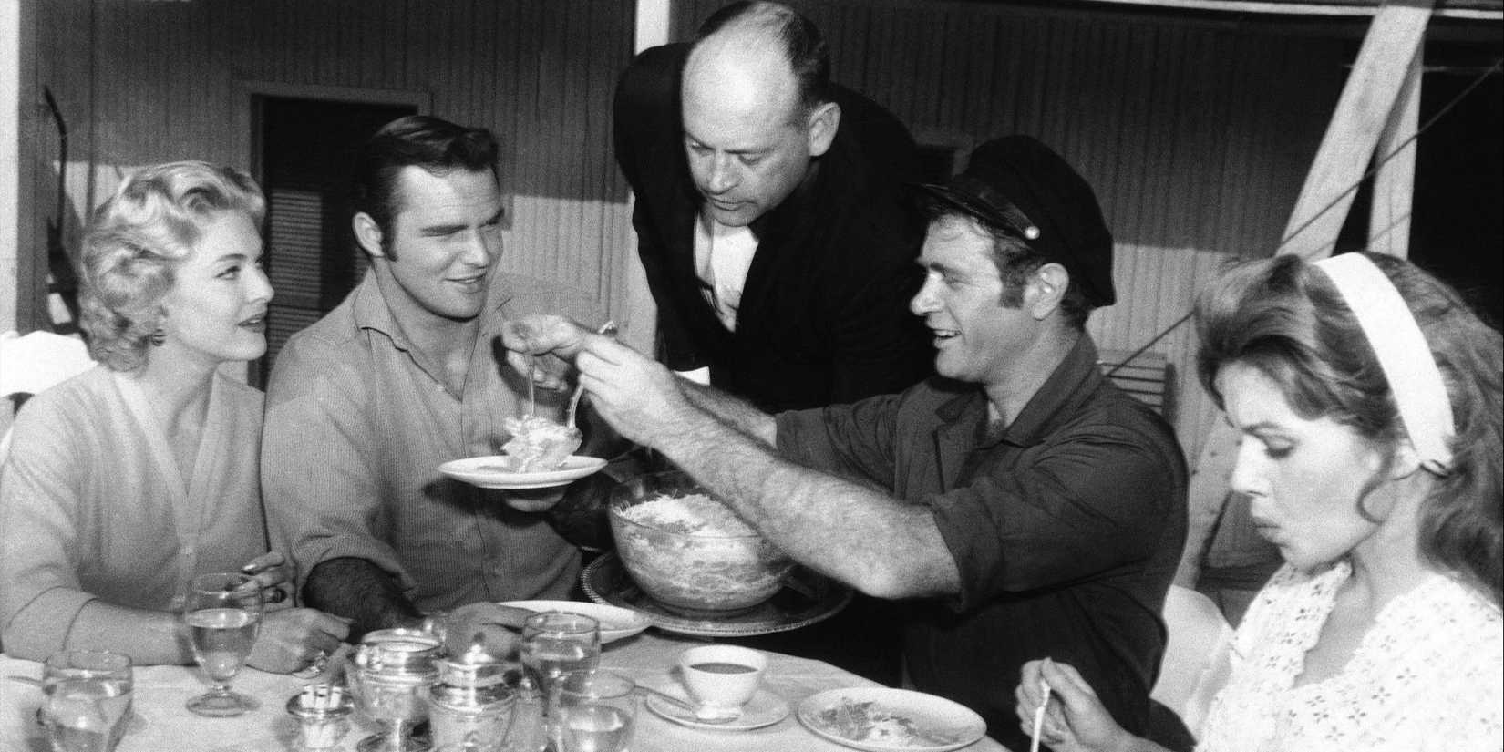 Ben Frazer (Burt Reynolds) and the other characters in Riverboat having a meal.