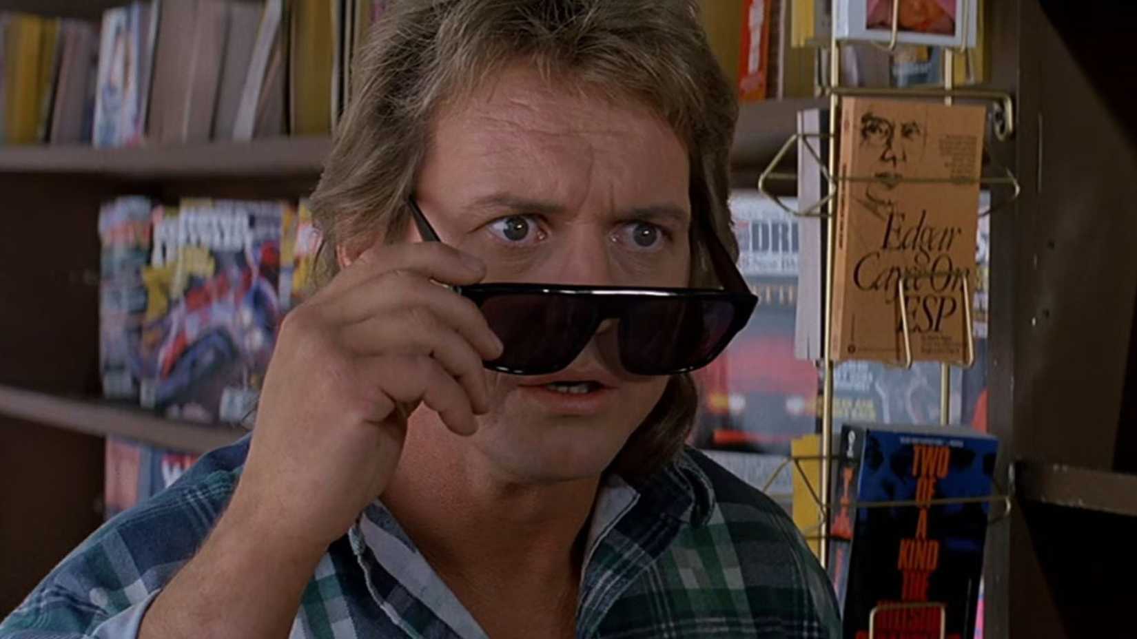 Roddy Piper as Nada peeks past his glasses in They Live