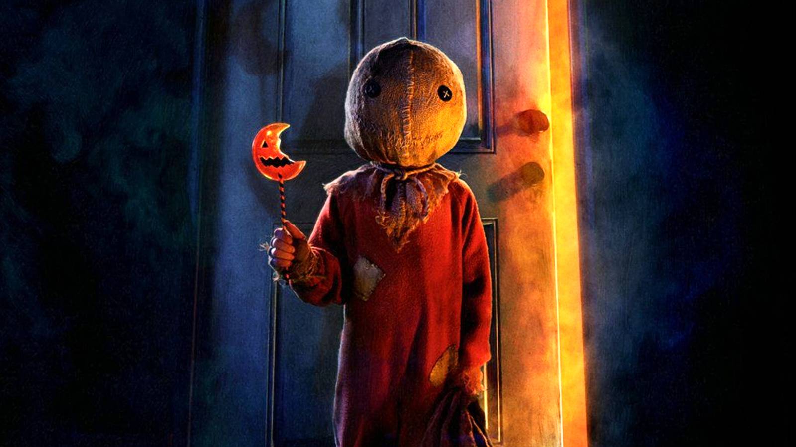 Sam holds a pumpkin candy and a bag next to a door in Trick r Treat movie poster