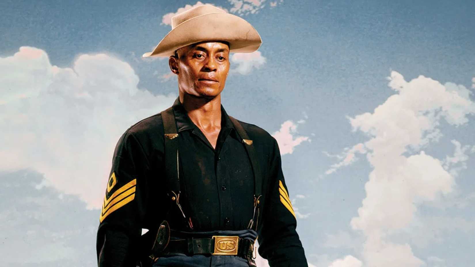 Woody Strode stands against a blue sky in uniform in Sergeant Rutledge