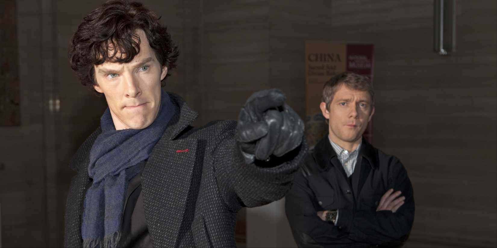 Sherlock Holmes (Benedict Cumberbatch) apontando enquanto Watson (Martin Freeman) está atrás dele em Sherlock