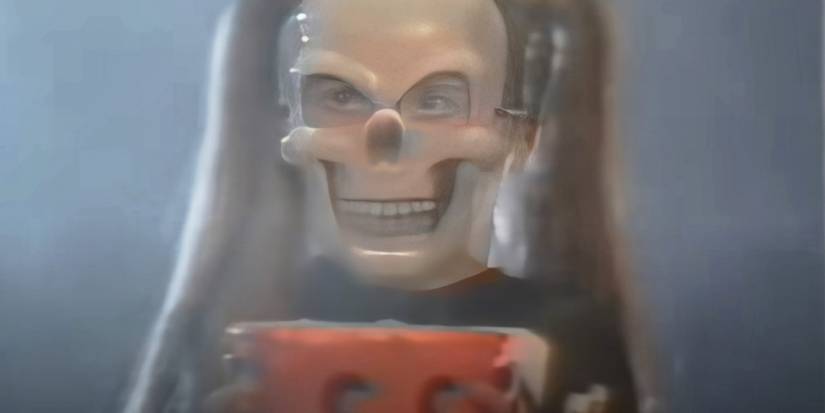 Someone wearing a skull mask and holding a pumpkin bucket in V/H/S/Halloween