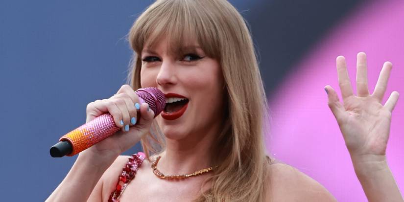 Taylor Swift smiling and waving at the Aviva Stadium during the Eras Tour