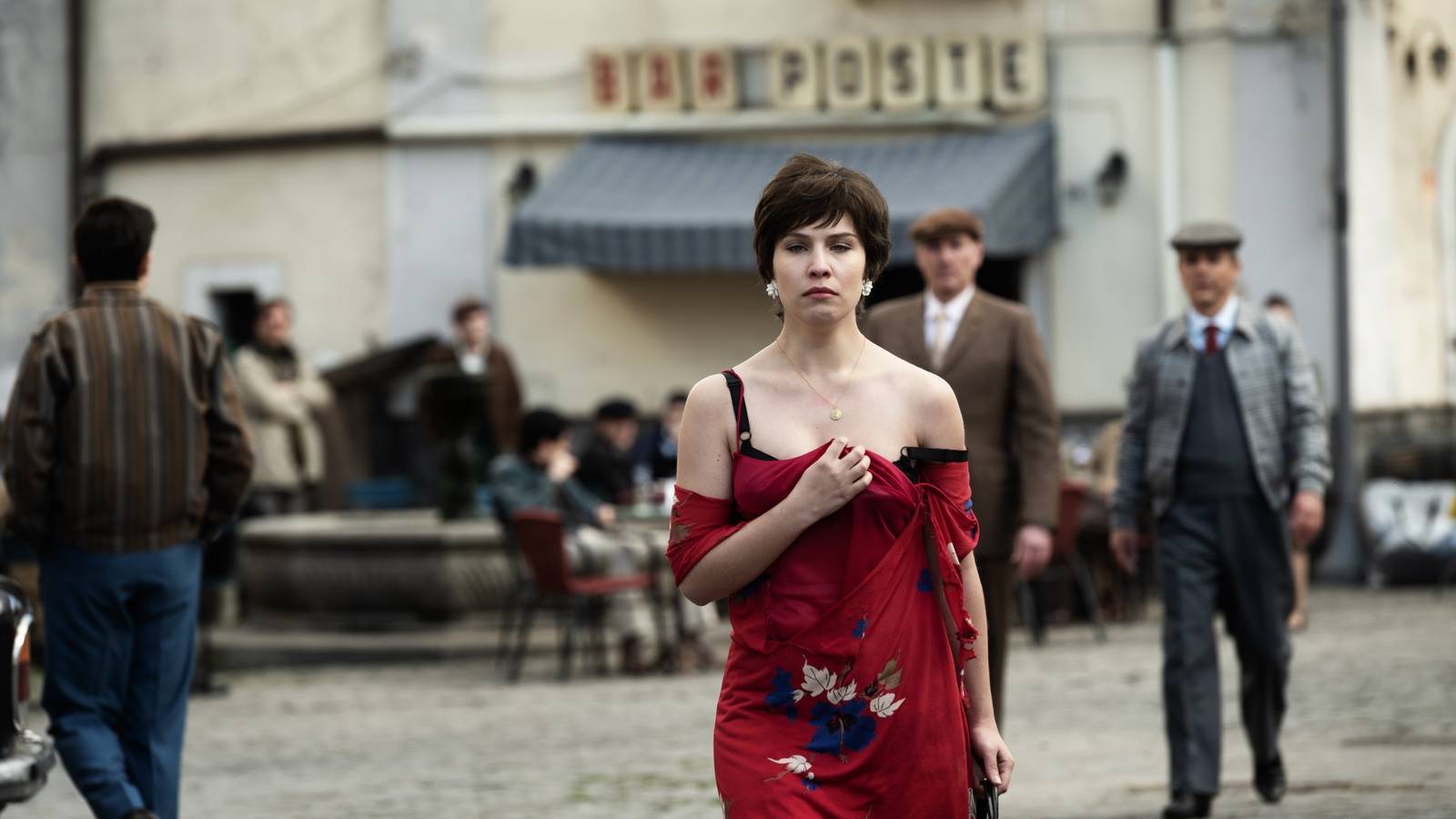 Francesca Olia wearing a red dress while walking through the streets in The Monster of Florence