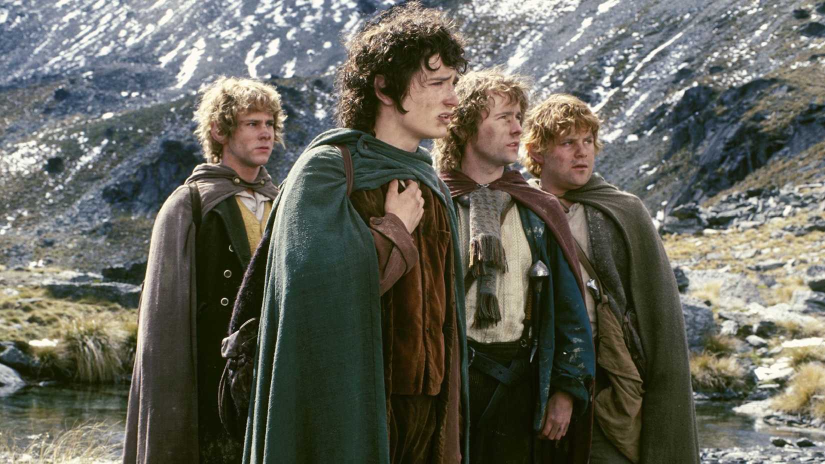 Os quatro hobbits perto de uma montanha em O Senhor dos Anéis