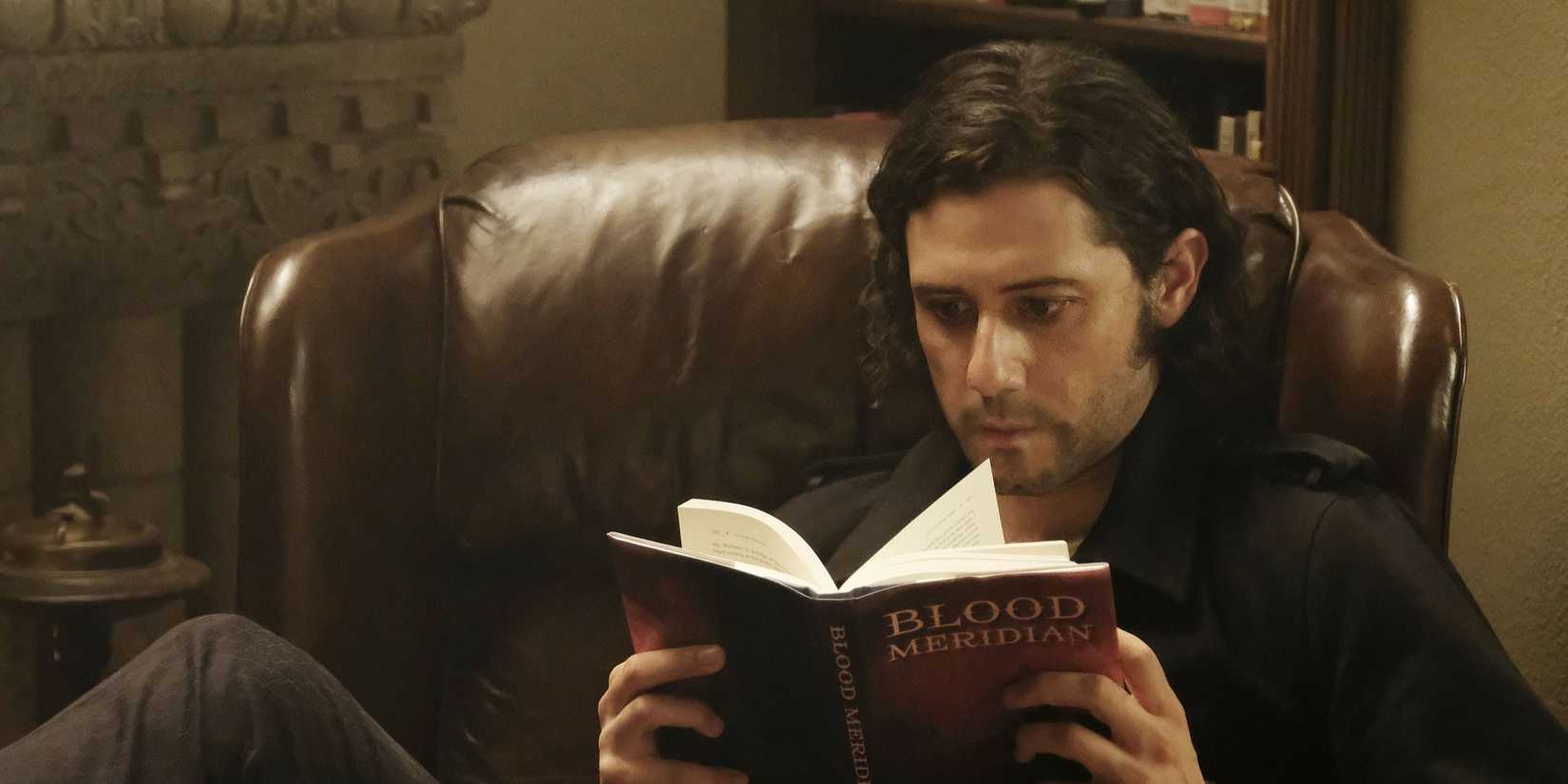 Eliot Waugh lendo um livro na 4ª temporada de The Magicians.