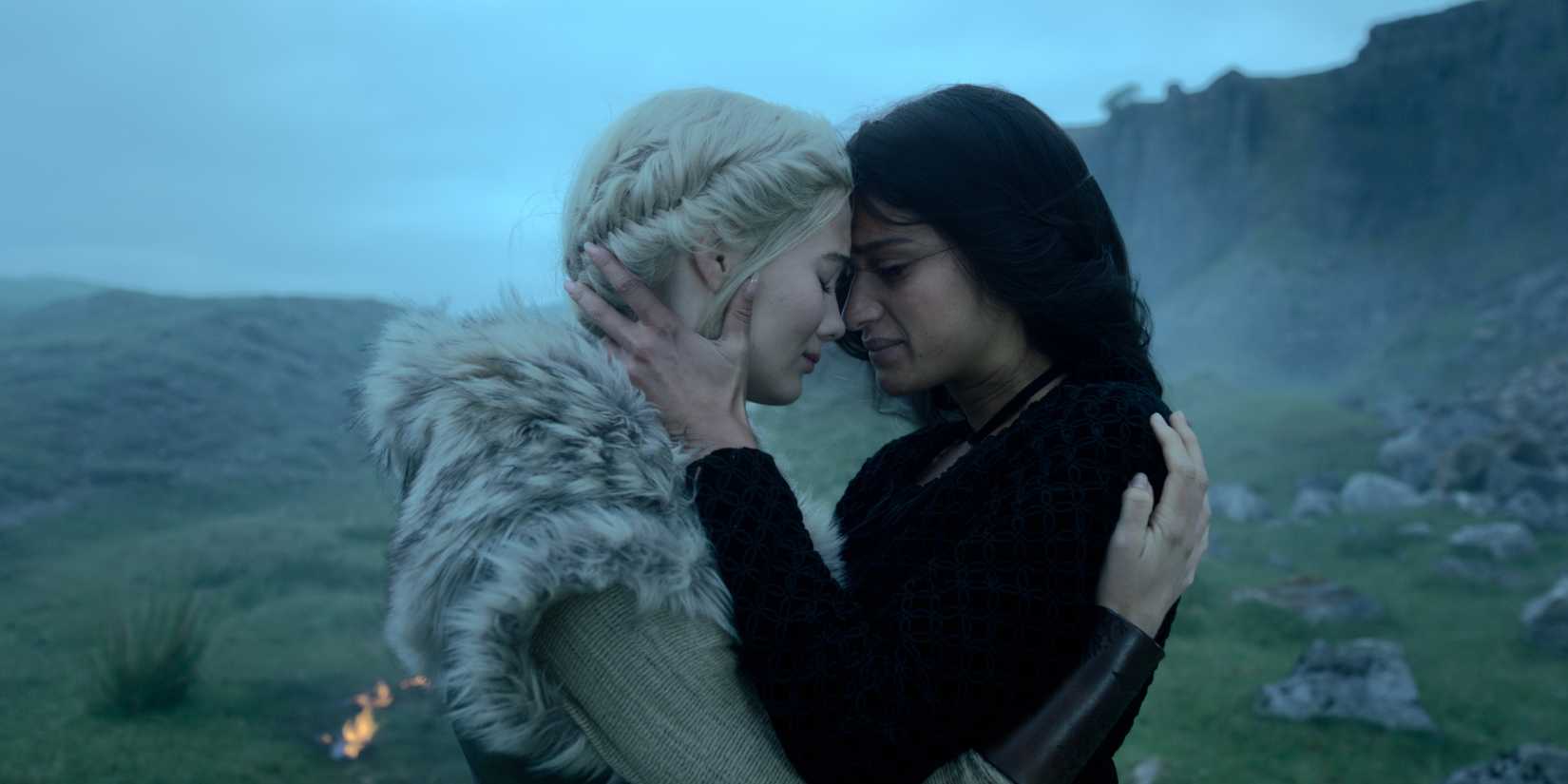 Two women leaning their heads against each other as they embrace in The Witcher season 4