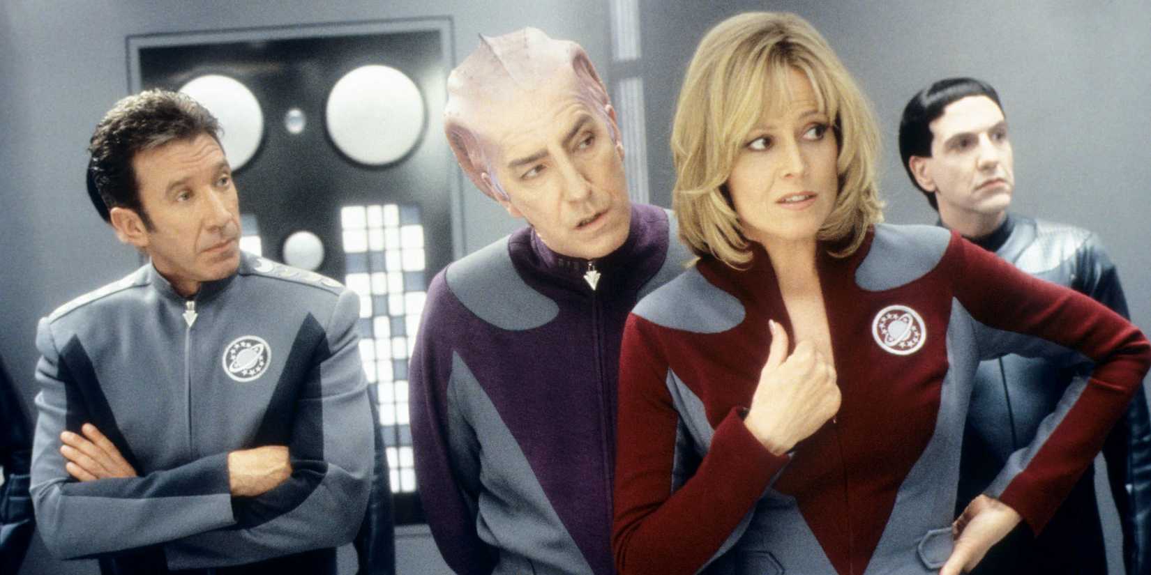 Tim Allen, Alan Rickman and Sigourney Weaver all lean forward to look at something with expressions of dismay in a scene from Galaxy Quest