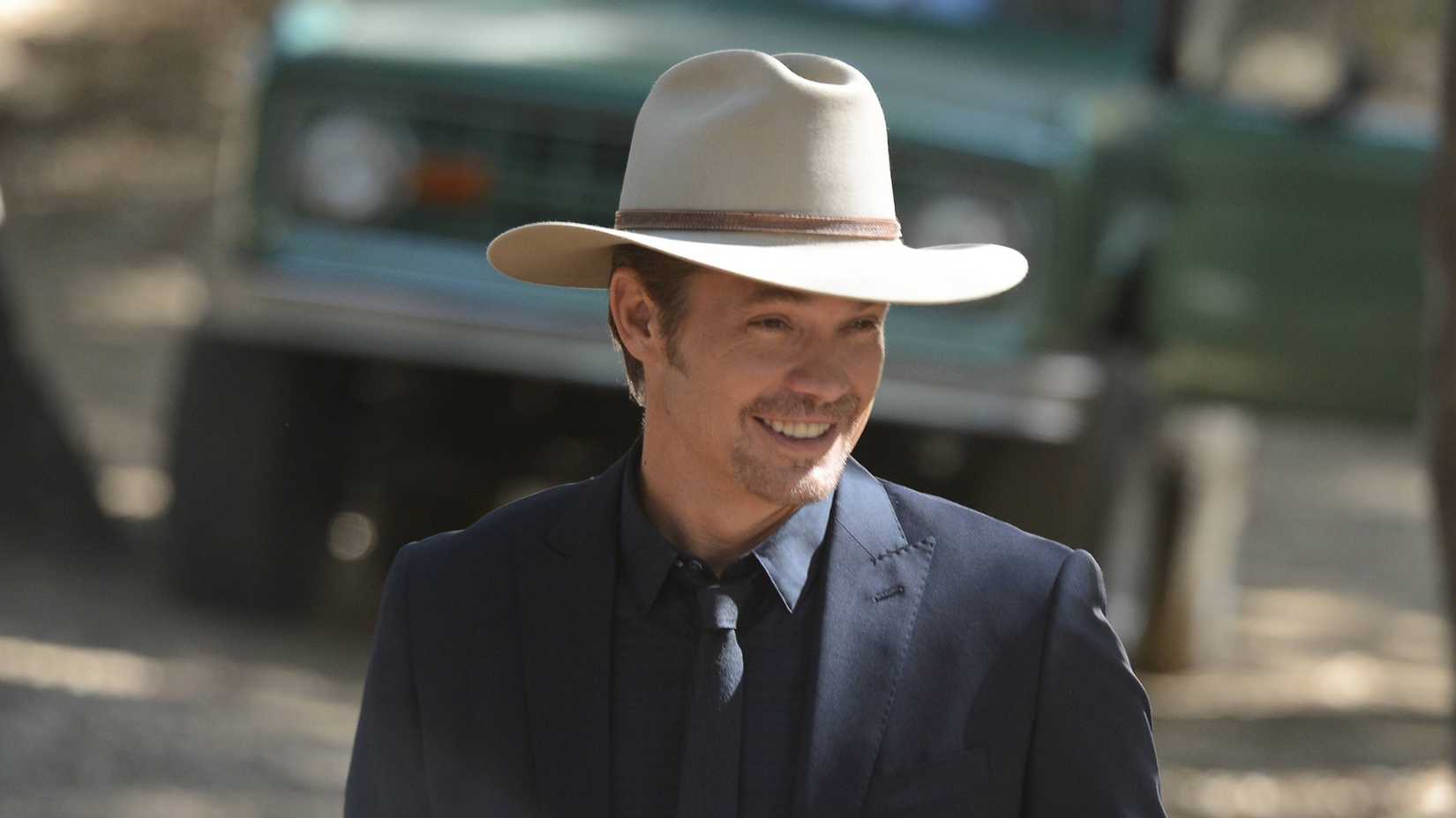 Timothy Olyphant sorrindo como Raylan Givens em Justified