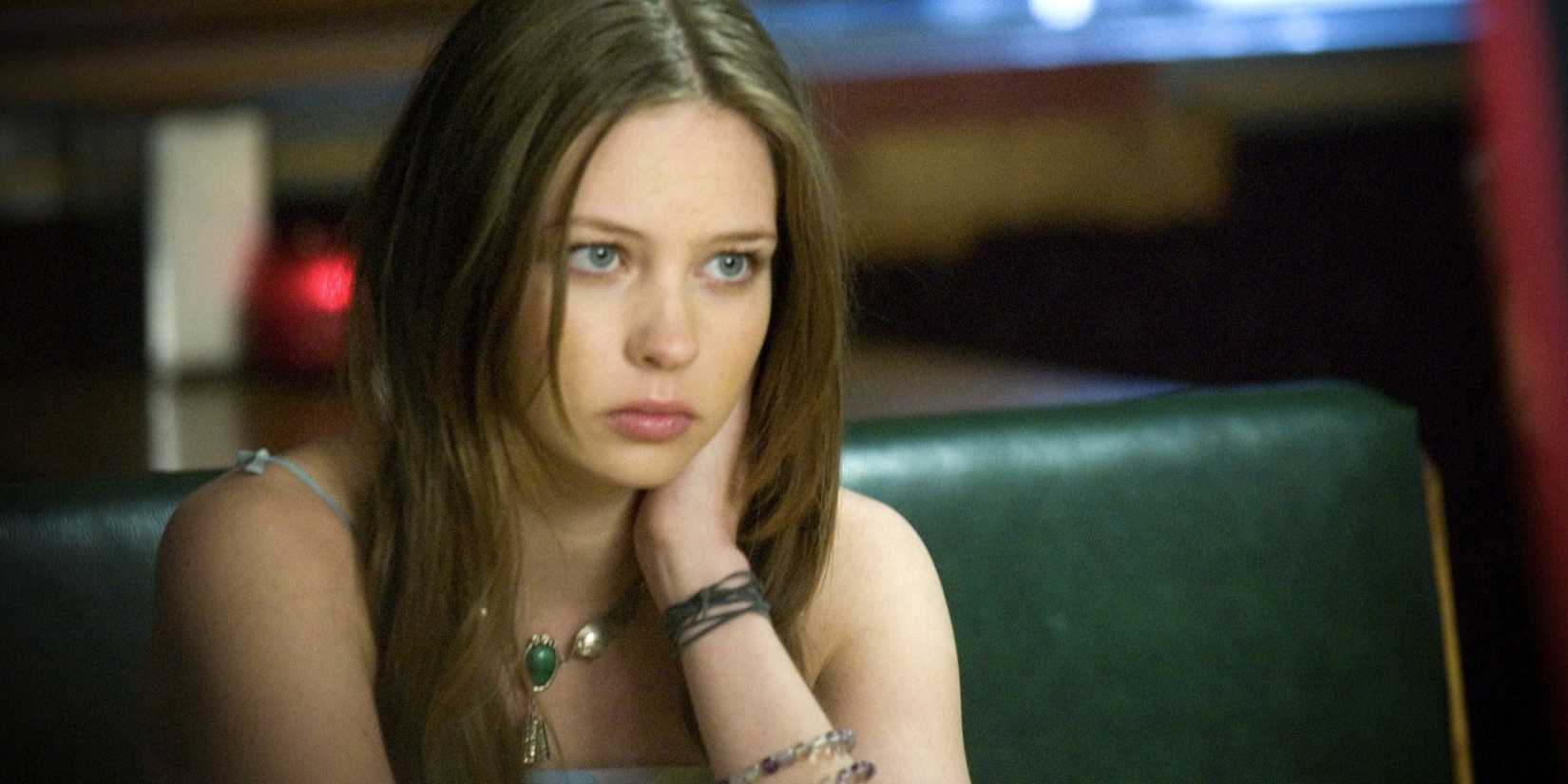Daveigh Chase as Samantha Darko sitting in a diner and looking sad as she stares off into the distance in S. Darko.