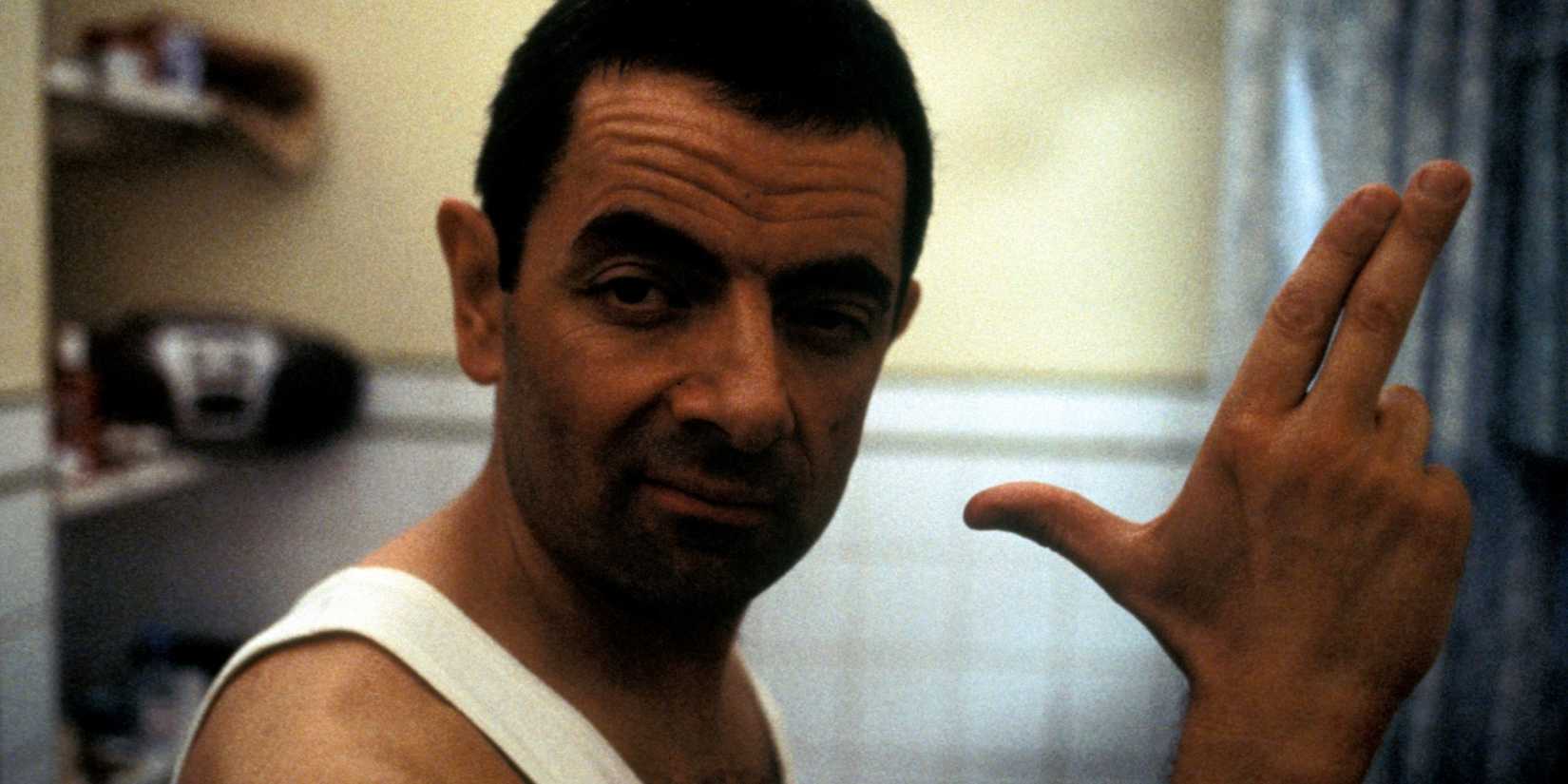 Rowan Atkinson as Johnny English posing in his bathroom mirror and pretending to be a spy in Johnny English.