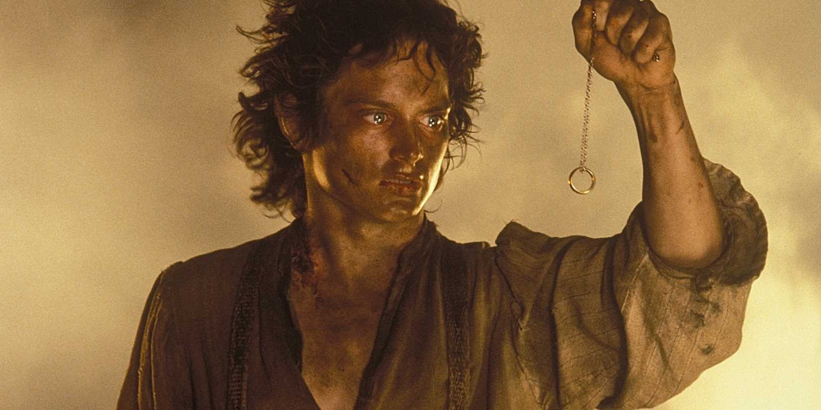 A dirty and exhausted Frodo holding the One Ring on a chain in front of him in The Lord of the Rings: The Return of the King.