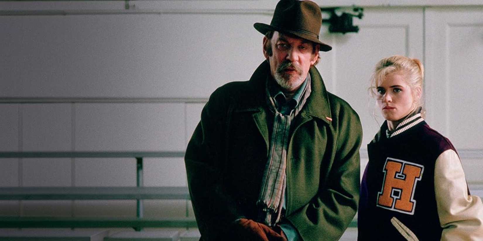 Buffy and Merrick staring off at something as they stand together in a big empty room in the Buffy the Vampire Slayer movie.