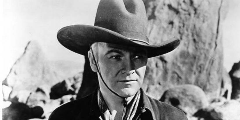 William Boyd as Hopalong Cᴀssidy wearing a cowboy hat and staring intently across a landscape in Hop-Along Cᴀssidy.