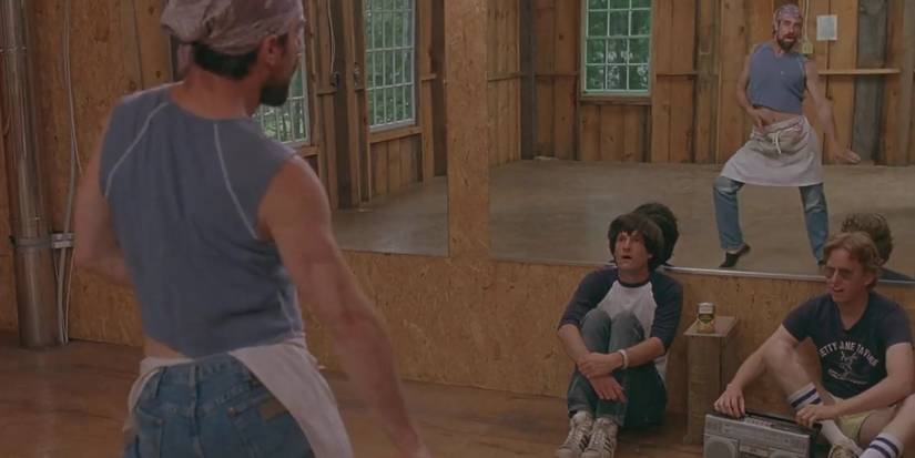 Gary and Coop sitting on the floor of the studio, watching Gene dance in the mirror behind them, in Wet H๏τ American Summer.