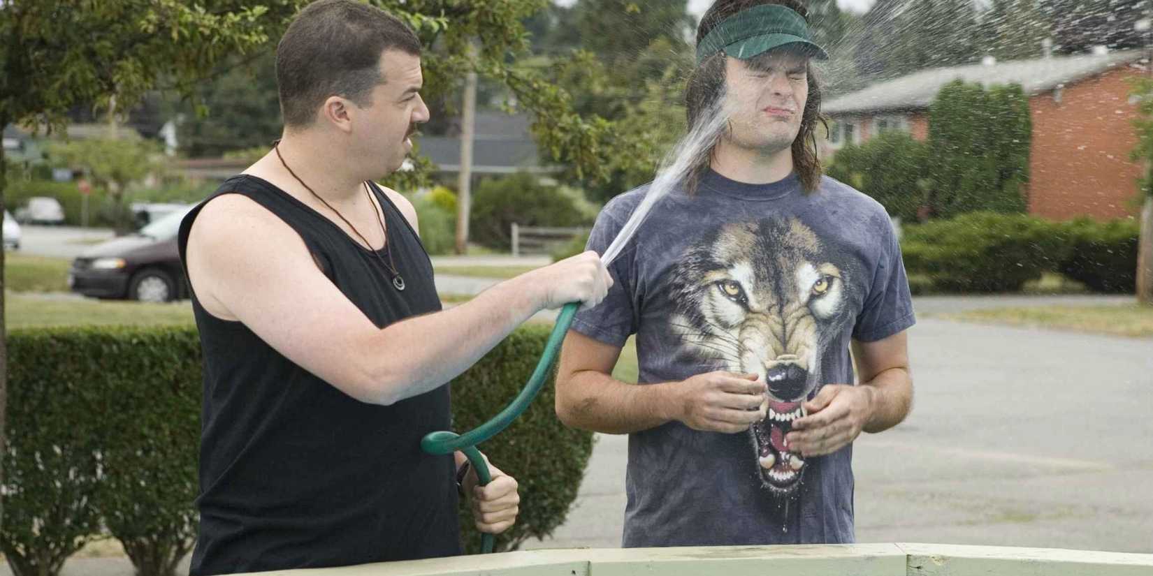Rico spraying Dave in the face with a hose as they stand by the pool, waiting for Rod, in H๏τ Rod.