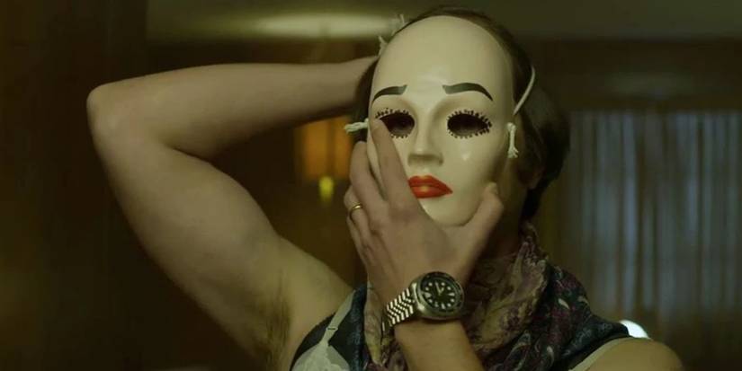 Dennis Rader aka BTK wearing a mask of a white face wearing red lipstick in the Mindhunter finale