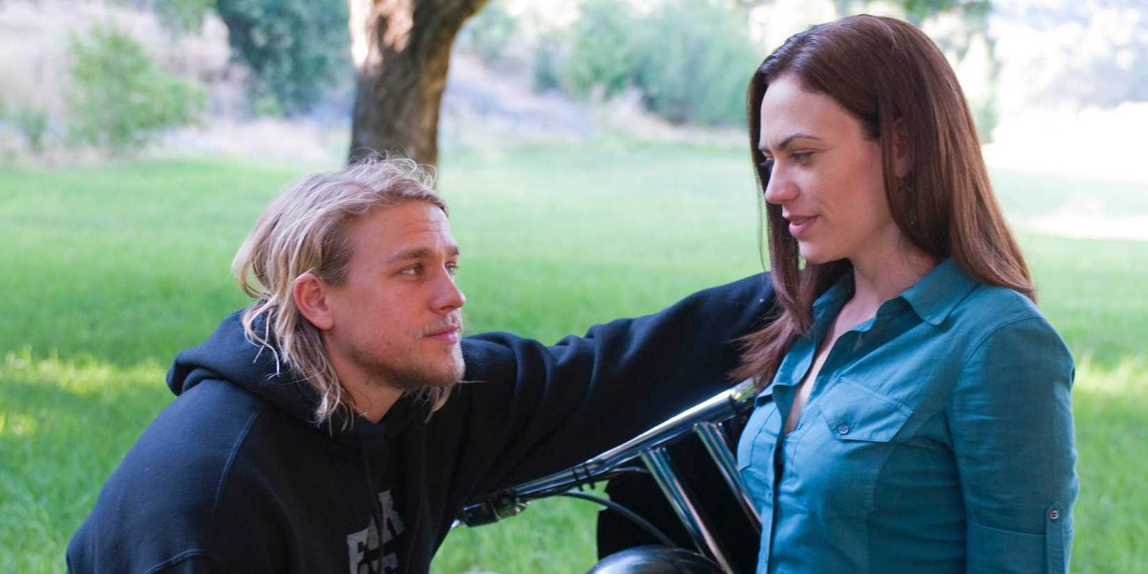 Tara smiling at Jax as he leans toward her in the park