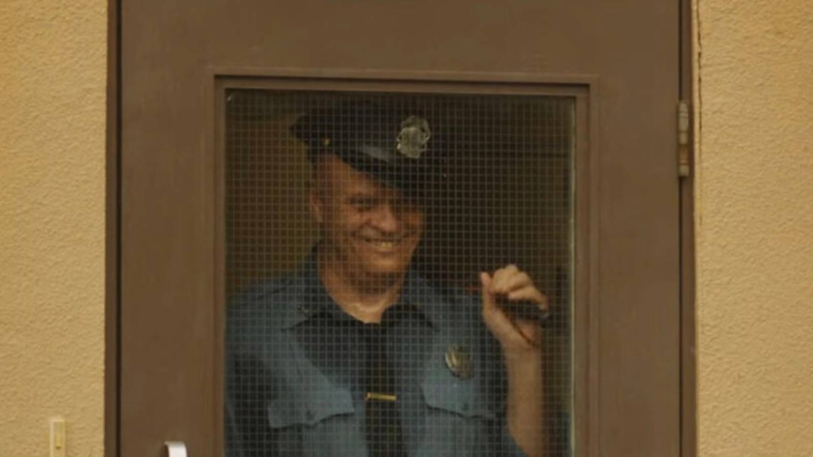 A creepy prison guard smiling like Pennywise in It Welcome to Derry episode 5