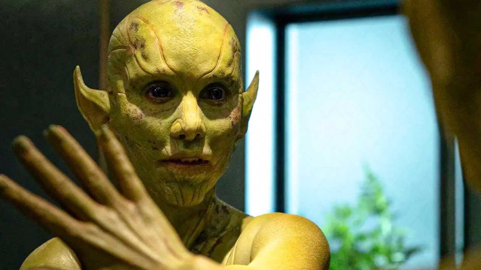A Skrull wipes a mirror to reveal her alien appearance in Secret Invasion