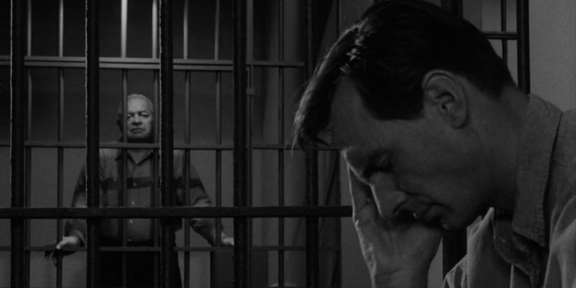 Adam Grant (Dennis Weaver) segurando a cabeça na prisão enquanto outro detento fala com ele em The Twilight Zone Shadow Play.