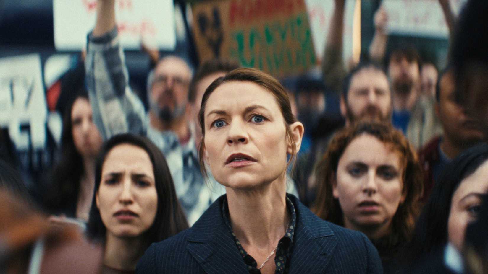 Aggie Wiggs (Claire Danes) looking concerned at a protest in The Beast in Me