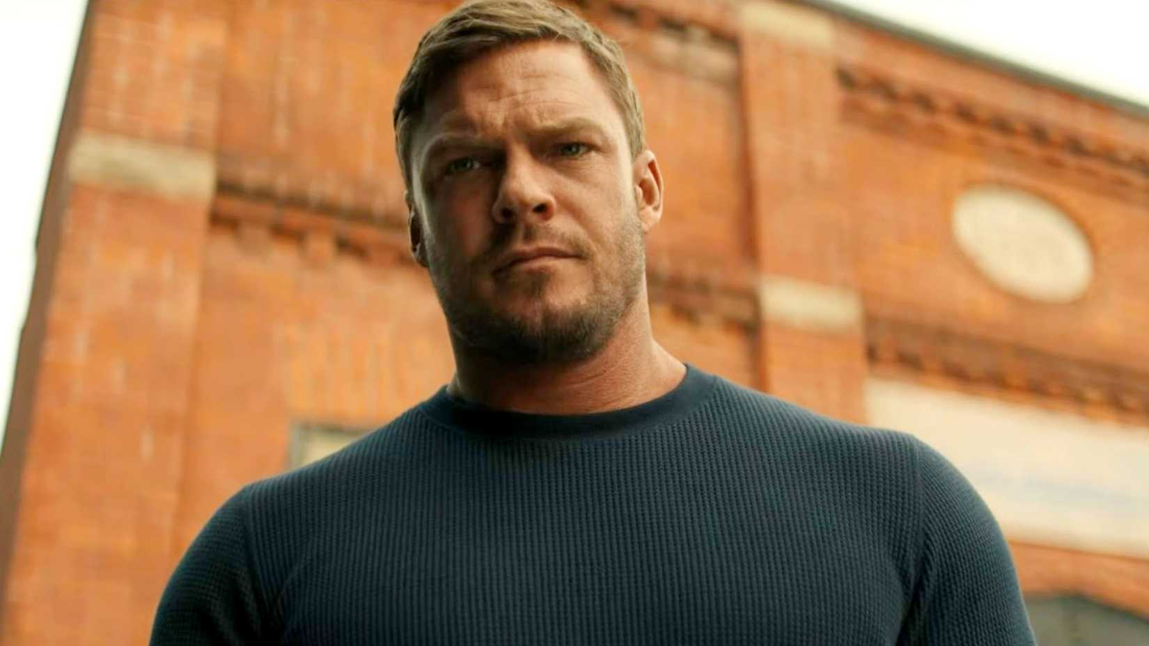 Alan Ritchson como Reacher com ar de desaprovação