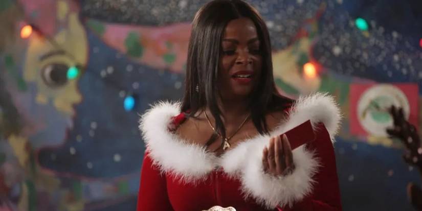 Ava vestida de Papai Noel olhando um cartão em Abbott Elementary