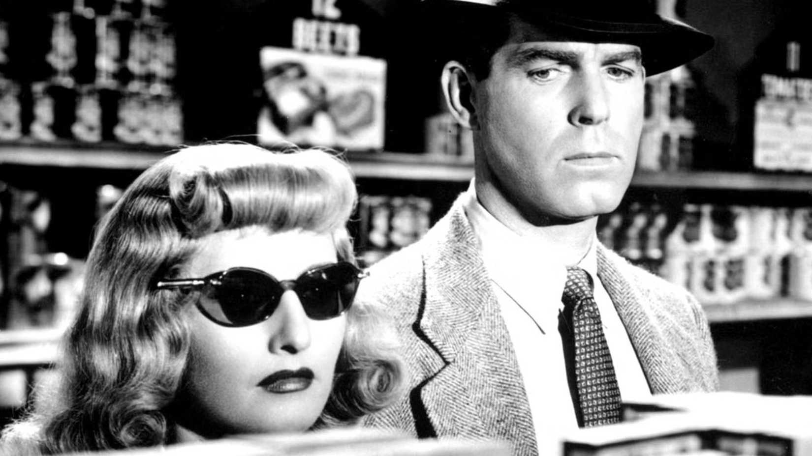 Barbara Stanwyck usando óculos escuros ao lado de Fred MacMurray em Pacto de Sangue (1944)