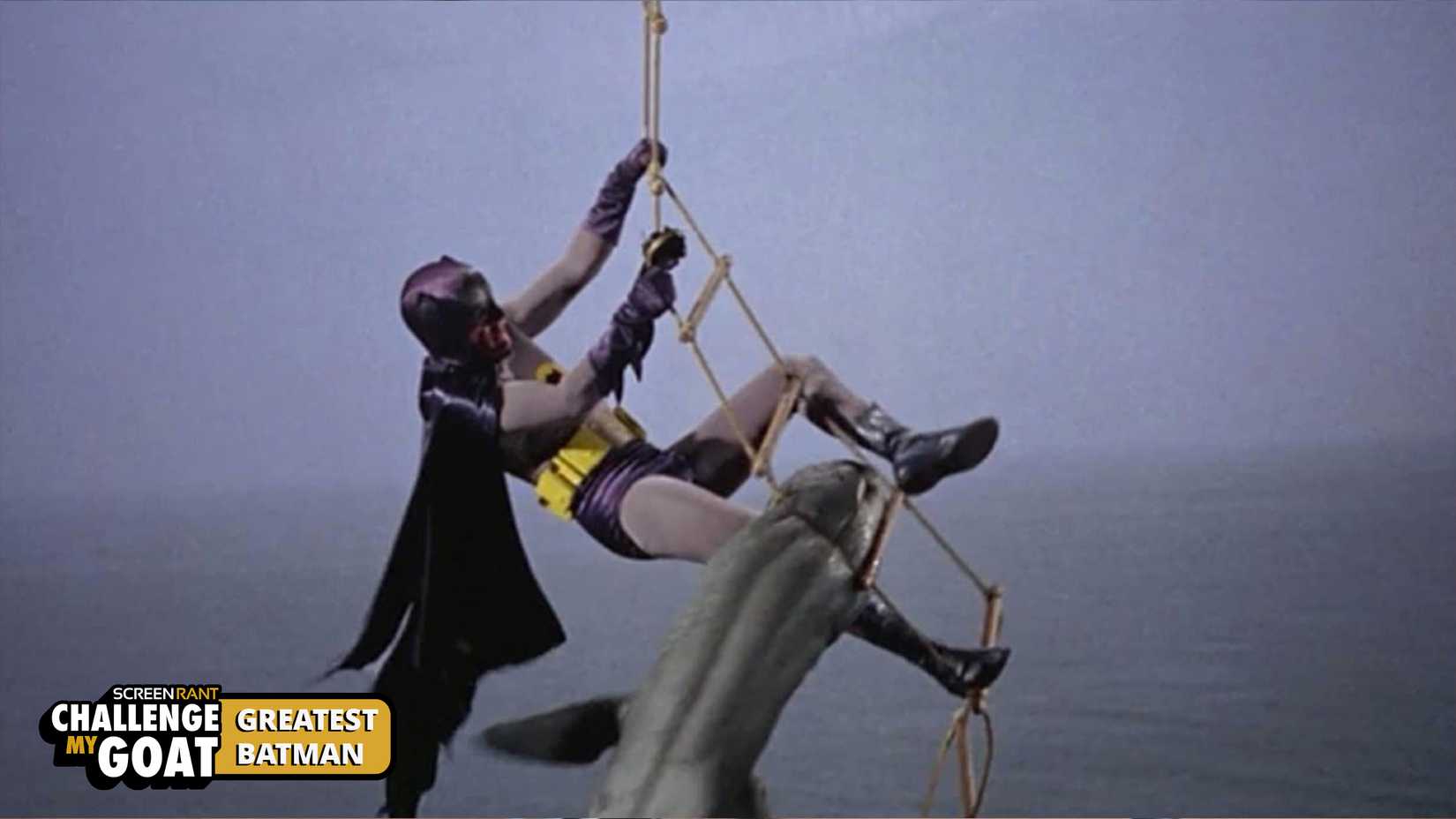 Batman hangs onto a rope ladder while fighting a shark.