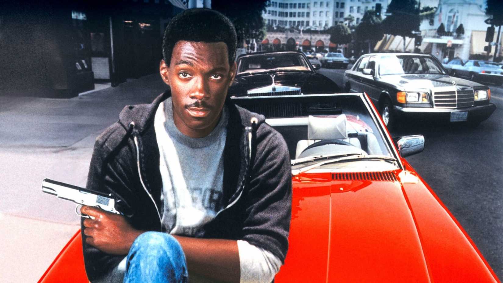 Axel Foley senta no capô de seu carro no pôster de Um Tira da Pesada