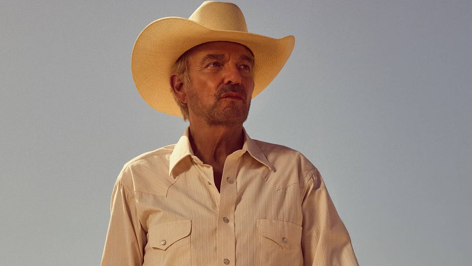 Billy Bob Thornton as Tommy looking stoic while standing in an open environment in Landman season 2