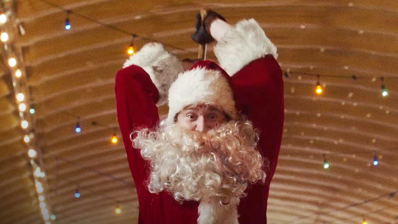 Billy dressed as Santa with blood splatters and holding an axe above his head in Silent Night Deadly Night 2025
