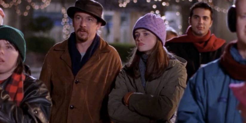 Bootsy (Brian Tarantina) ao lado de Rory (Alexis Bledel) na praça da cidade com uma expressão perplexa em Gilmore Girls.
