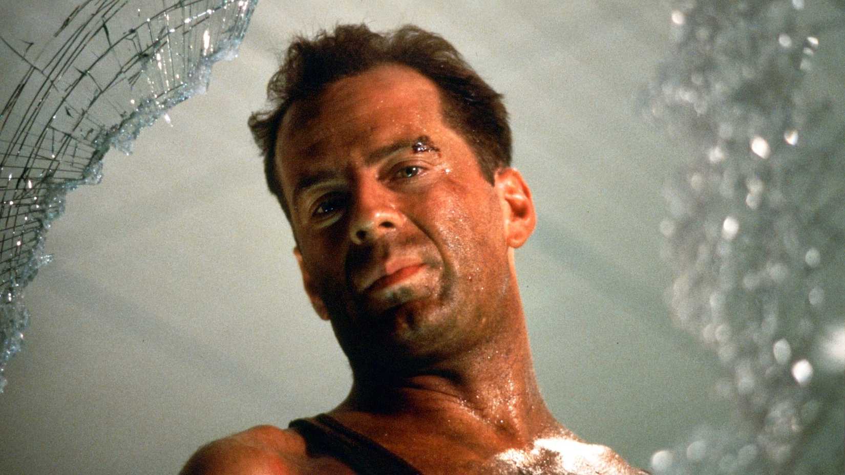 Bruce Willis as McClane looking through a hole in a window in Die Hard