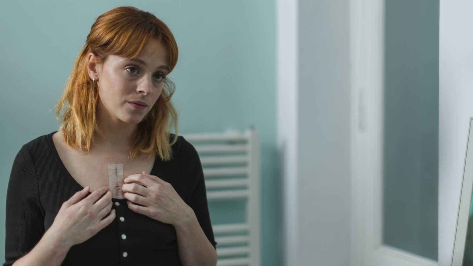 Clara olhando a cicatriz de sua cirurgia cardíaca em The Crystal Cuckoo