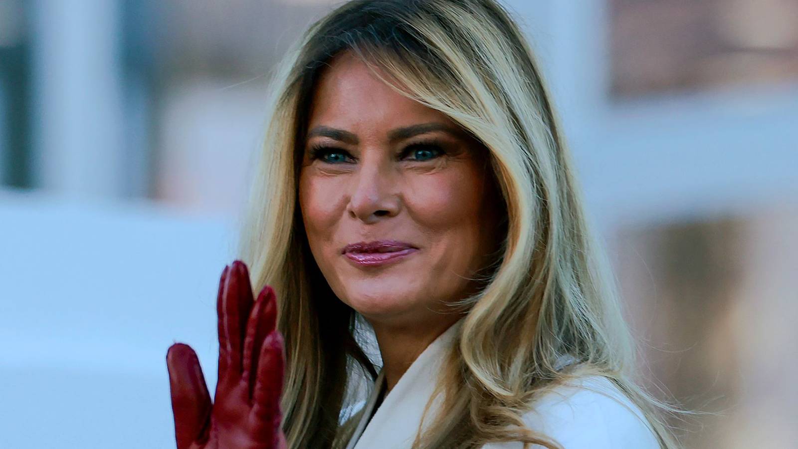 Melania Trump waving with hand in red glove 
