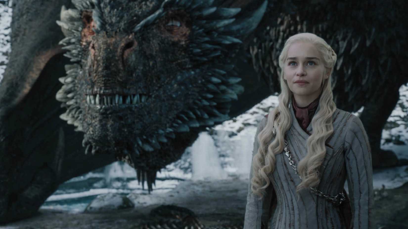 Daenerys está ao lado de um dragão em Game of Thrones.