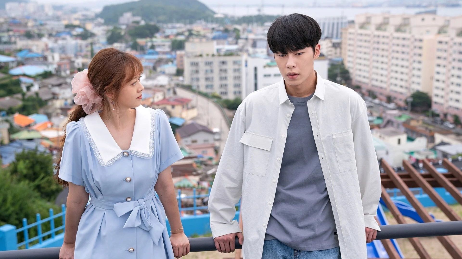 Un uomo e una donna appoggiati a una ringhiera nel K-Drama Do Do Sol Sol La La Sol