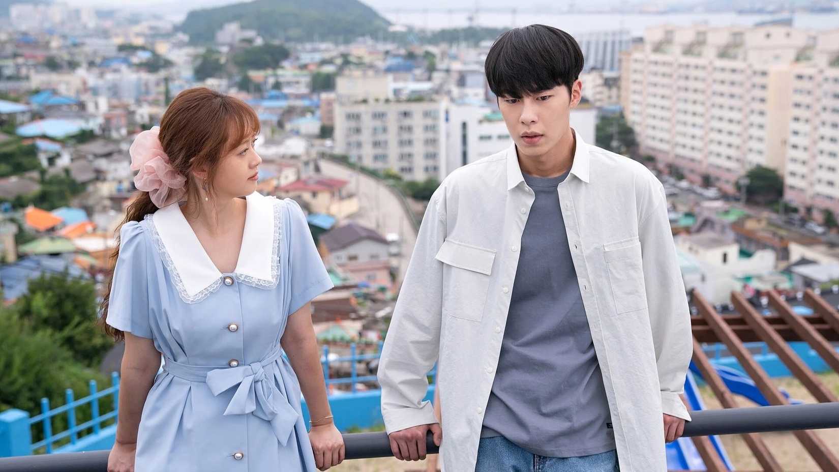 Um homem e uma mulher encostados em uma grade no K-Drama Do Do Sol Sol La La Sol.