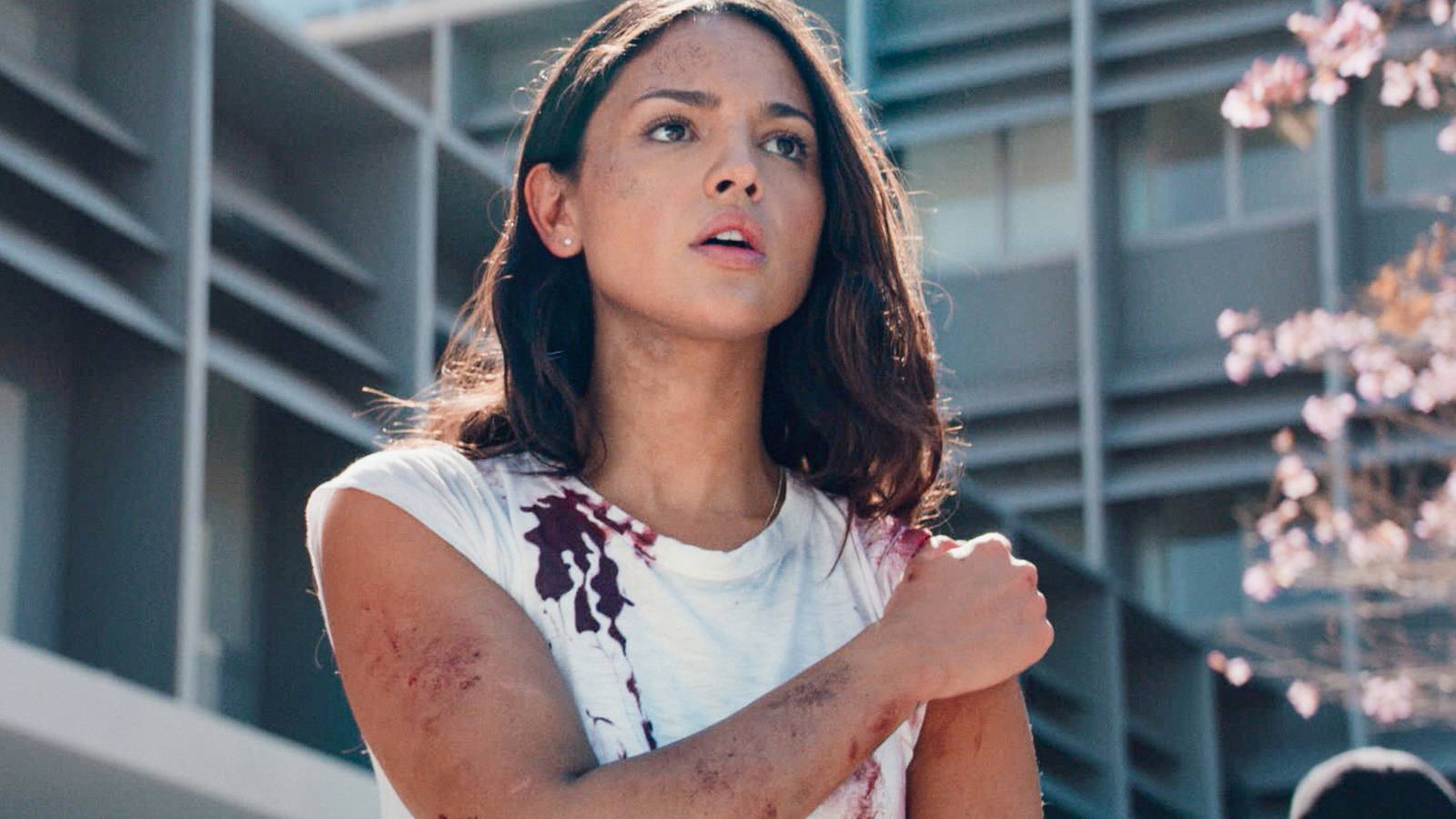 Eiza Gonzaelz injured and bloodied, holding her shoulder, in Ambulance