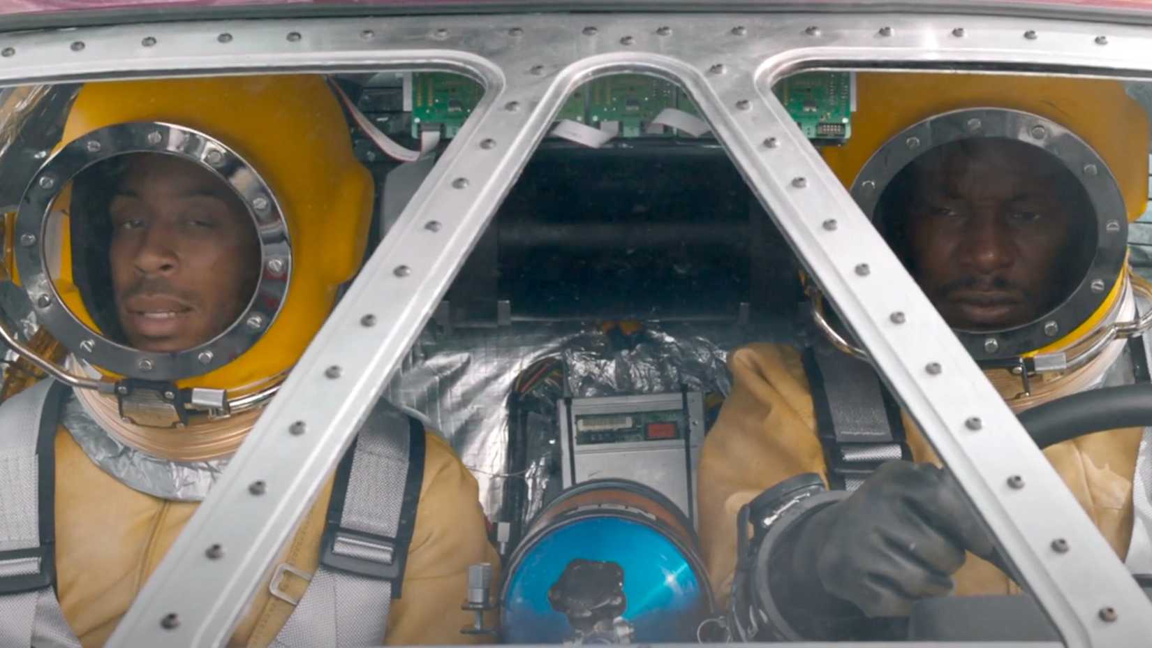 Tej e Tyrese usam trajes espaciais enquanto dirigem um carro-foguete em F9