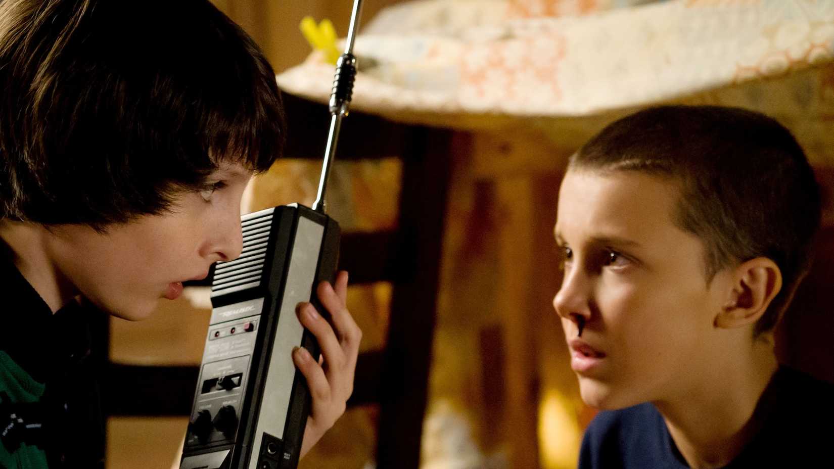Finn Wolfhard's Mikeand Millie Bobby Brown's Eleven sit together in Stranger Things season 1